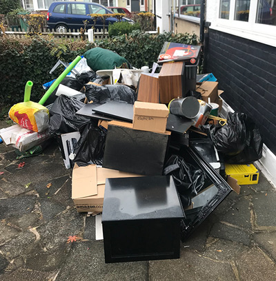 Household junk and furniture piled outside front of property before same-day rubbish collection in Arkley — Rubbish-Collection.com
